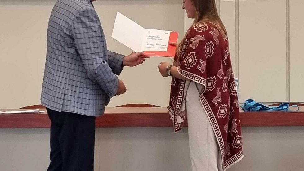 Organizator Konkursu wręcza dyplom i przekazuje gratulacje wygranej w konkursie Karinie Woźniak